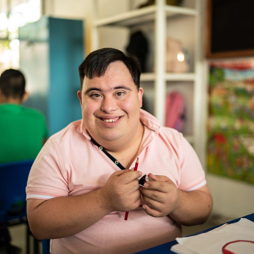 NDIS Provider Southport participant smiling while taking part in a creative activity at a community centre. NDIS Personal Care