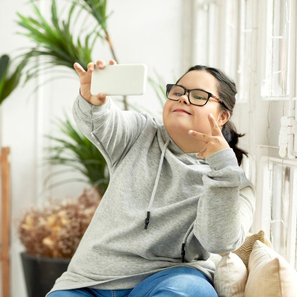 A participant enjoying greater independence with NDIS support in Pimpama while taking a selfie at home.
